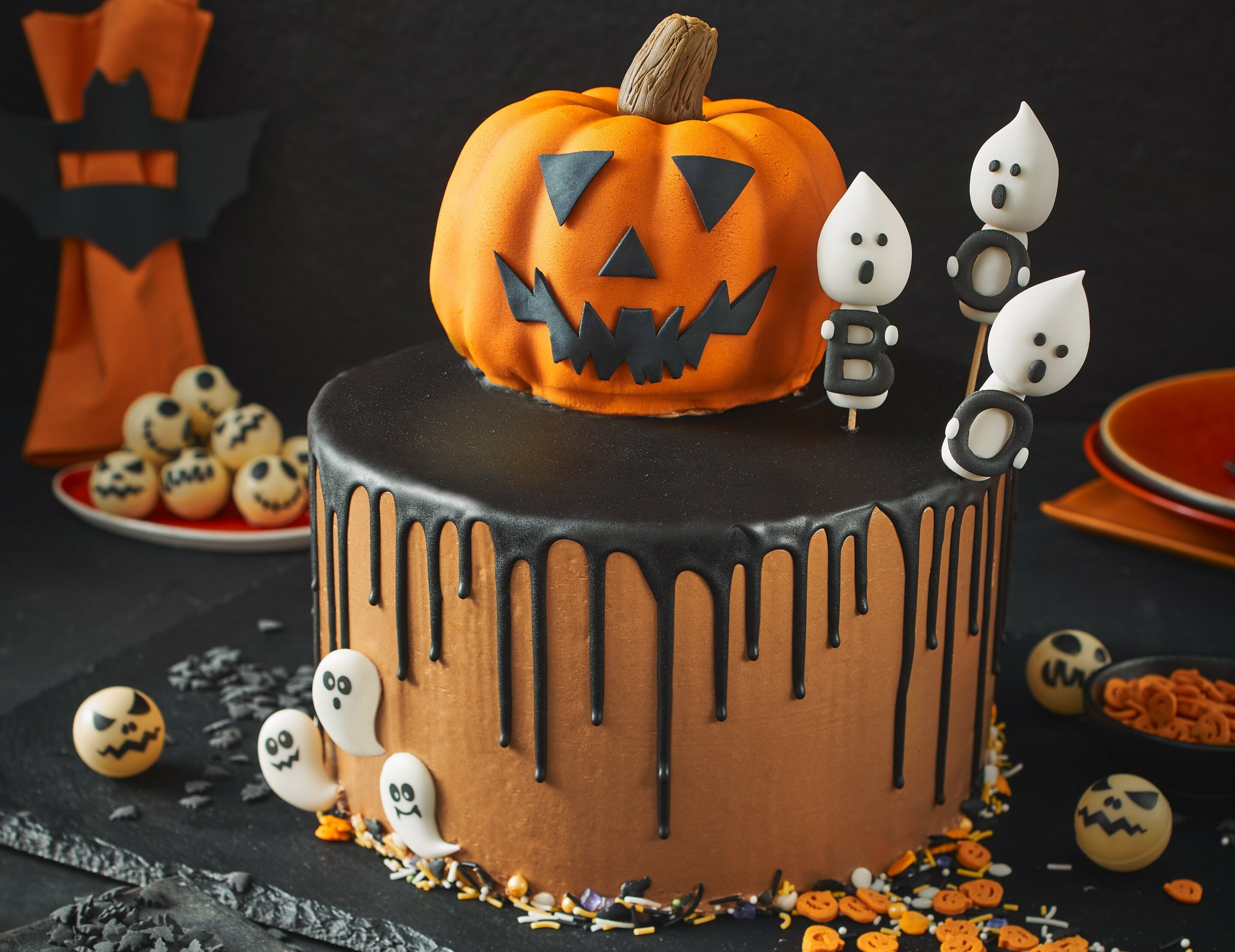 Eine leckere mehrstöckige Halloween-Torte mit Kürbisaufsatz und Co.